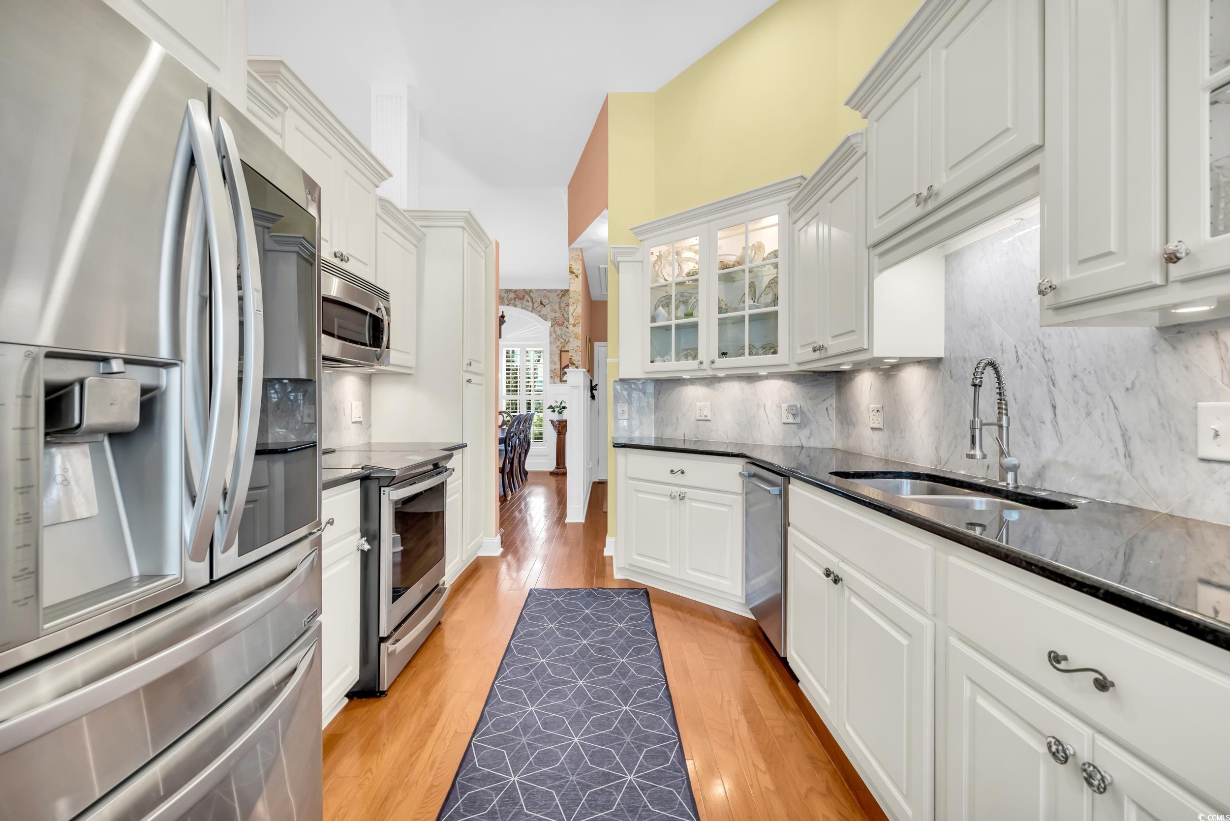3112 Bayhaven Drive Myrtle Beach, SC 29579 - Photo 14 of 40 Kitchen featuring stainless steel appliances, glass insert cabinets, light wood finished floors, and white cabinetry