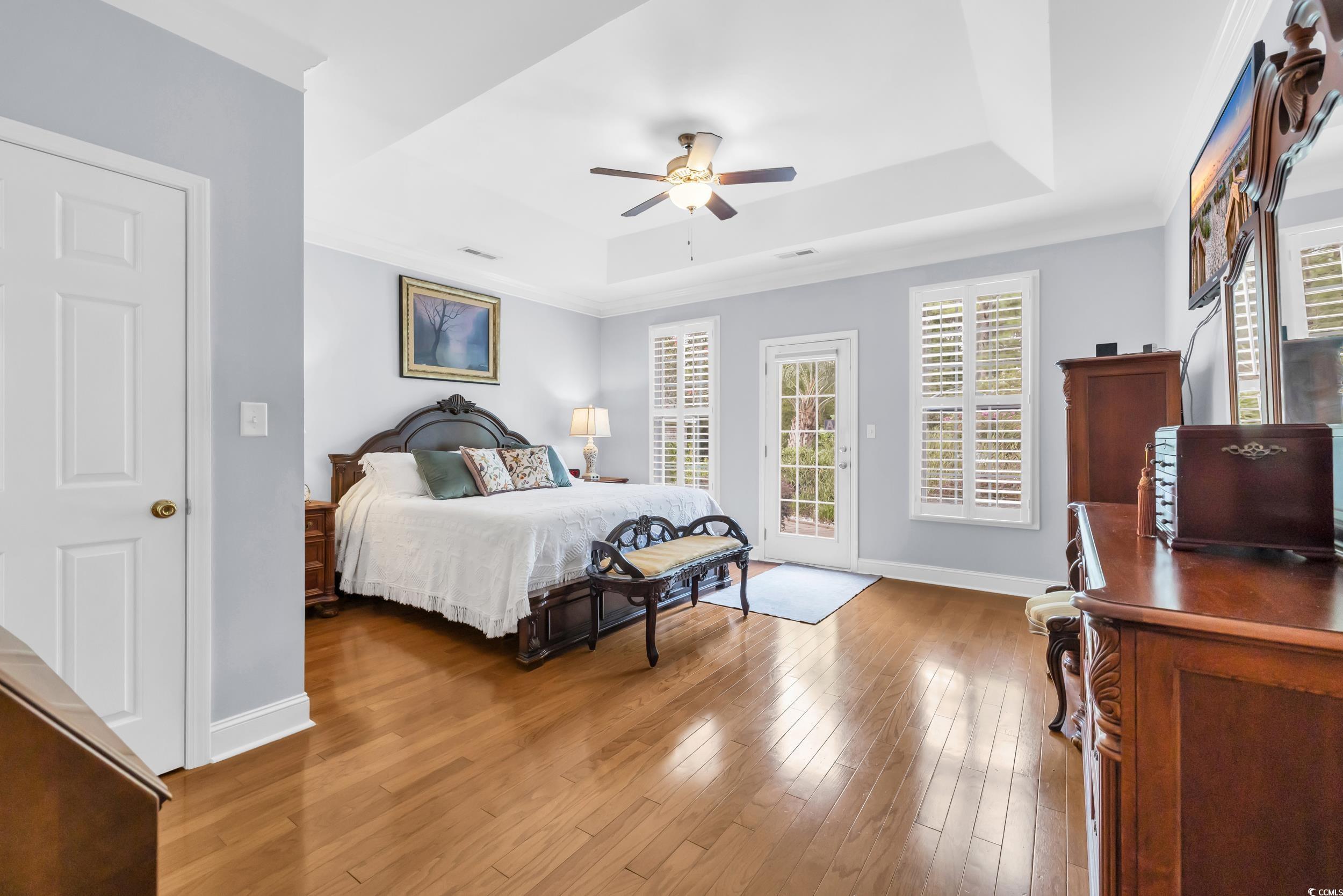 3112 Bayhaven Drive Myrtle Beach, SC 29579 - Photo 23 of 40 Bedroom with a raised ceiling, multiple windows, light wood-style flooring, and access to exterior