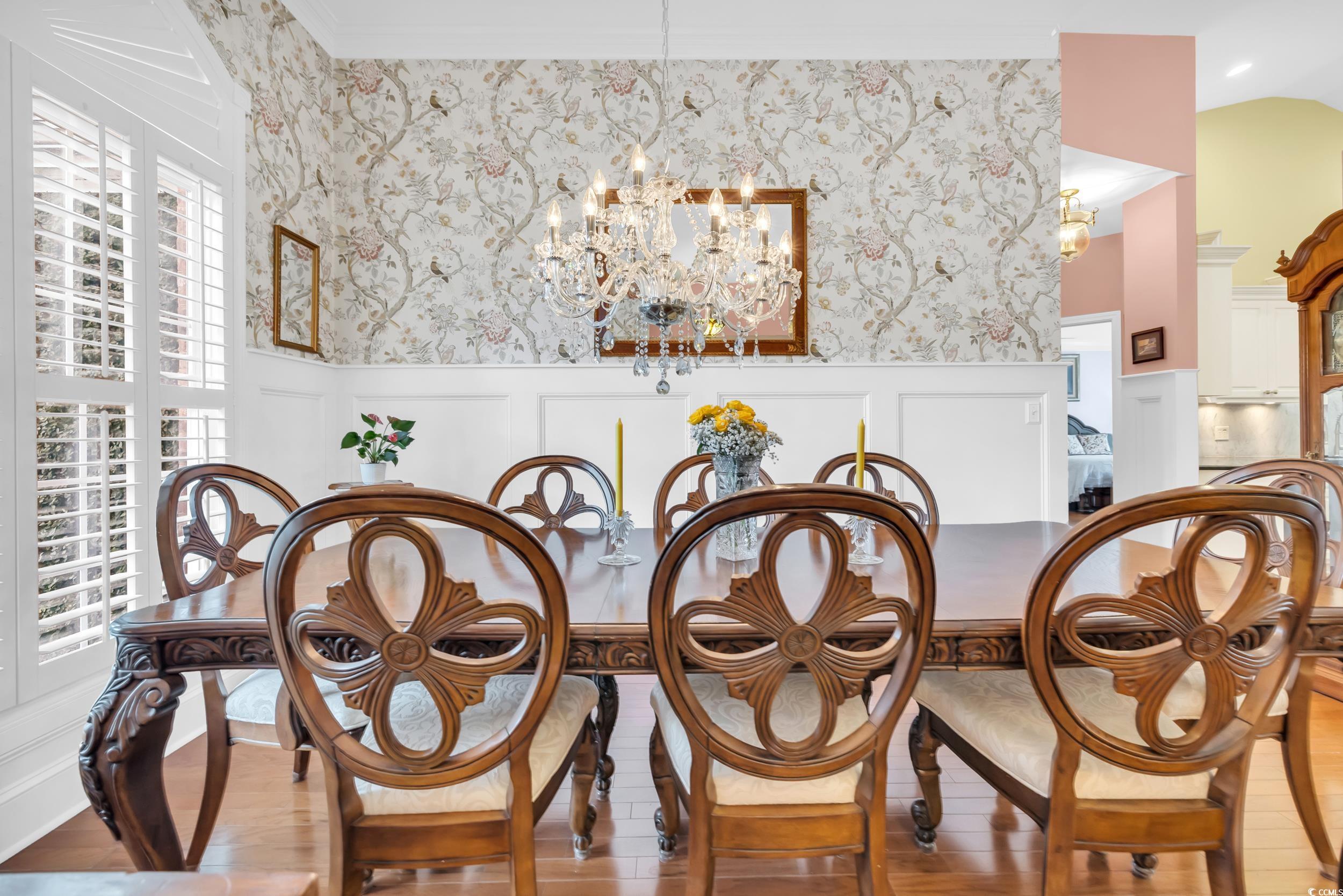 3112 Bayhaven Drive Myrtle Beach, SC 29579 - Photo 6 of 40 Dining area with a chandelier, a decorative wall, a wainscoted wall, wood finished floors, and wallpapered walls