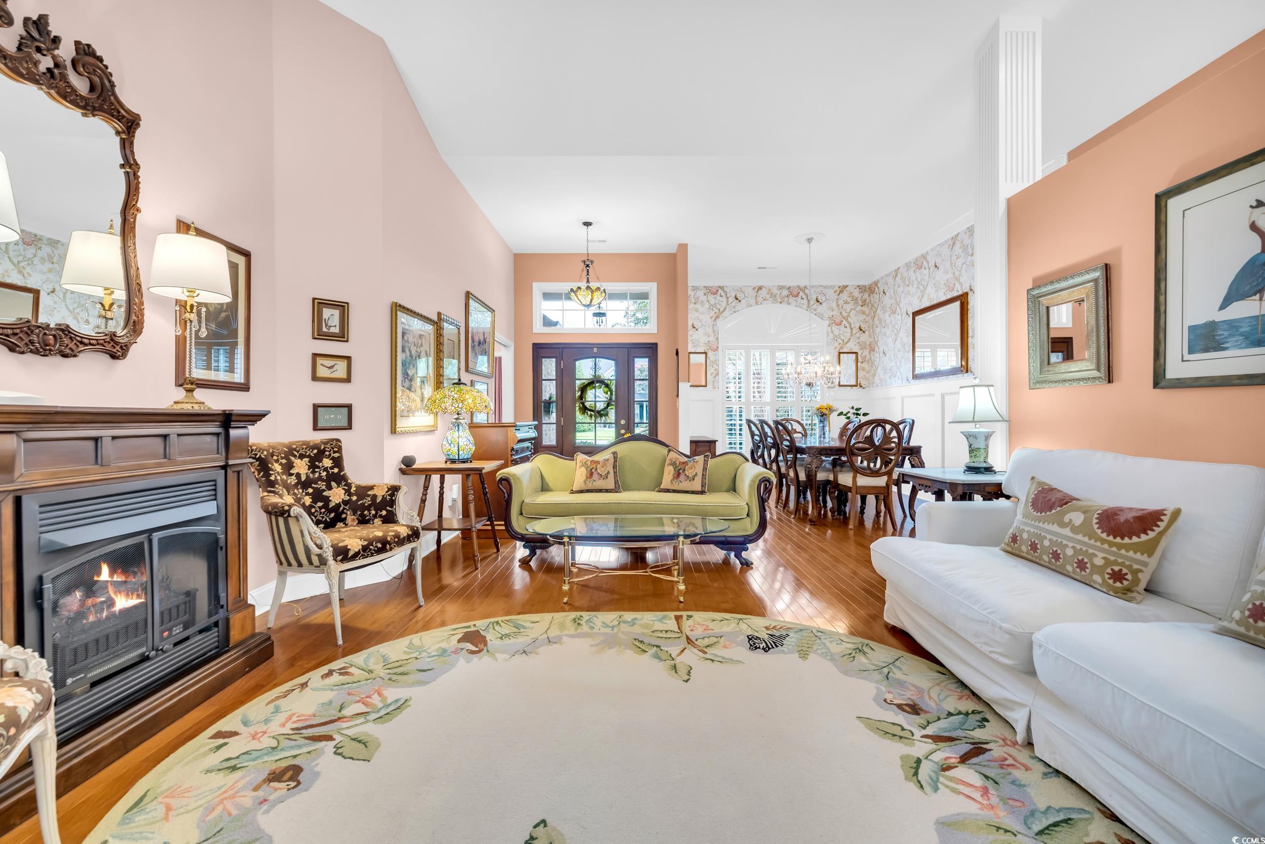3112 Bayhaven Drive Myrtle Beach, SC 29579 - Photo 8 of 40 Living area featuring wood finished floors, a lit fireplace, wallpapered walls, and wainscoting