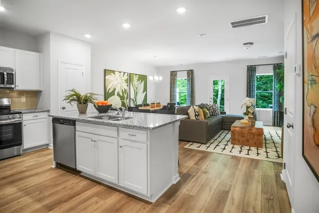 a large living room with granite countertop wooden floor a couch and a large window