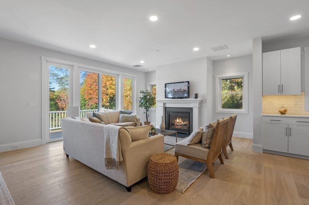 32 Pne Hl Road, Unit 32 Wenham, MA 01984 - Photo 17 of 36 a living room with furniture a fireplace and a floor to ceiling window