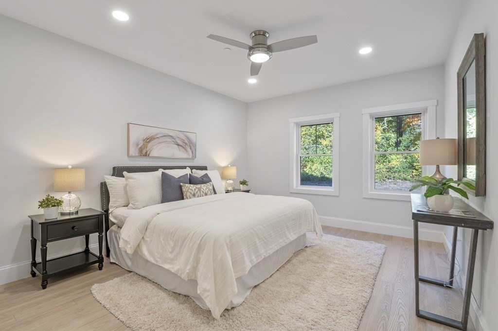 32 Pne Hl Road, Unit 32 Wenham, MA 01984 - Photo 26 of 36 a bedroom with a large bed chandelier and a window