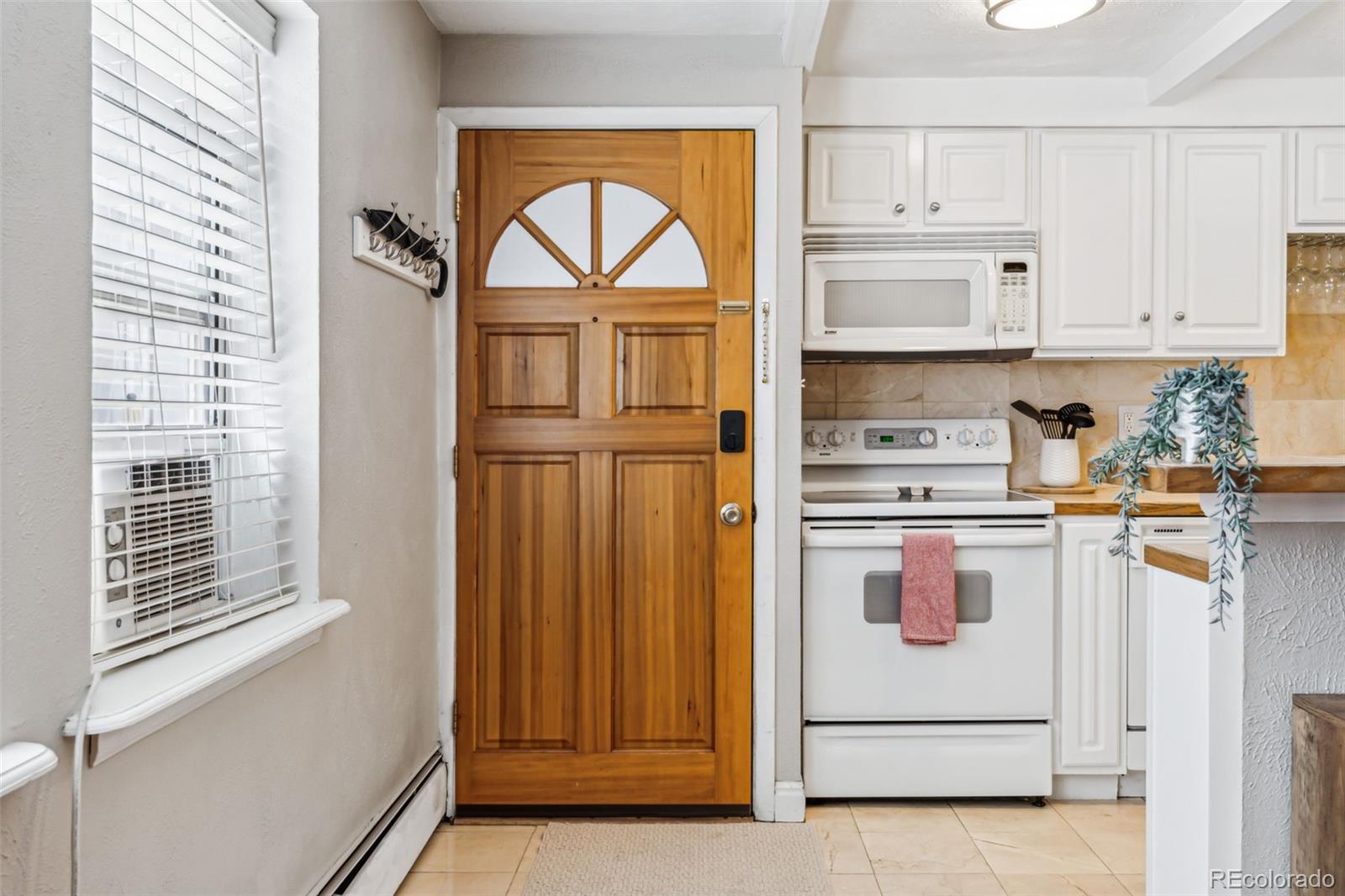 160 Jackson Street, Unit 5 Denver, CO 80206 - Photo 12 of 35 a kitchen with a refrigerator and white cabinets