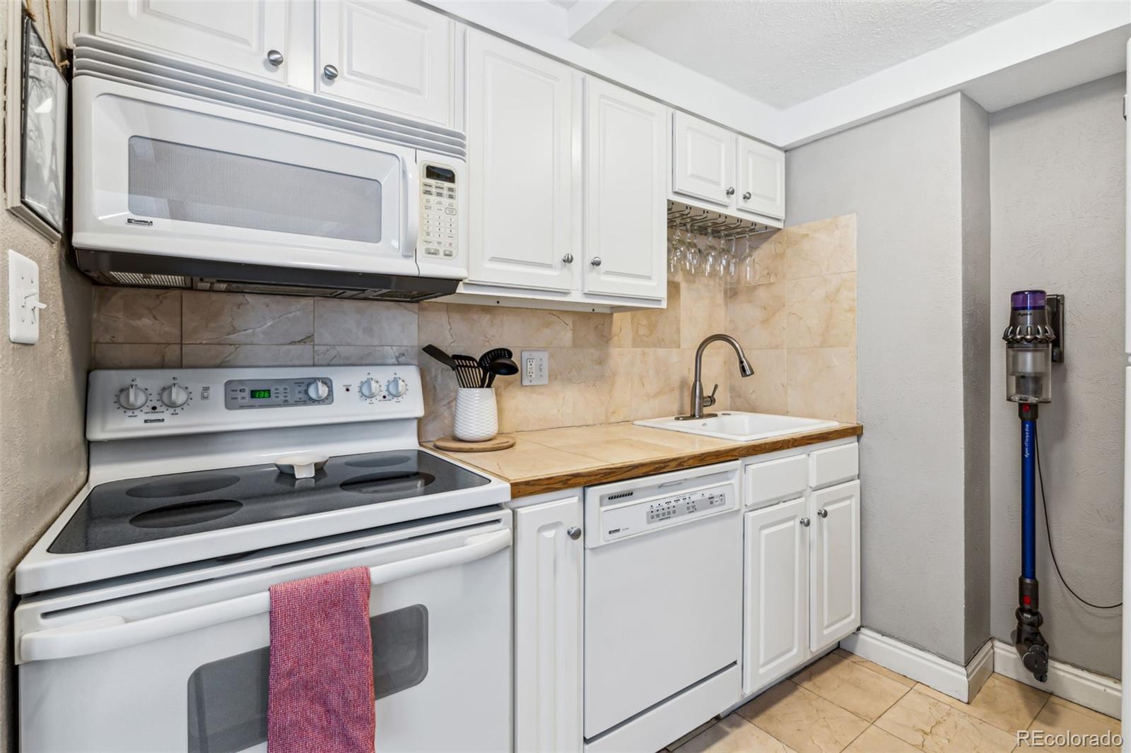 160 Jackson Street, Unit 5 Denver, CO 80206 - Photo 13 of 35 a kitchen with stainless steel appliances granite countertop a sink and a stove