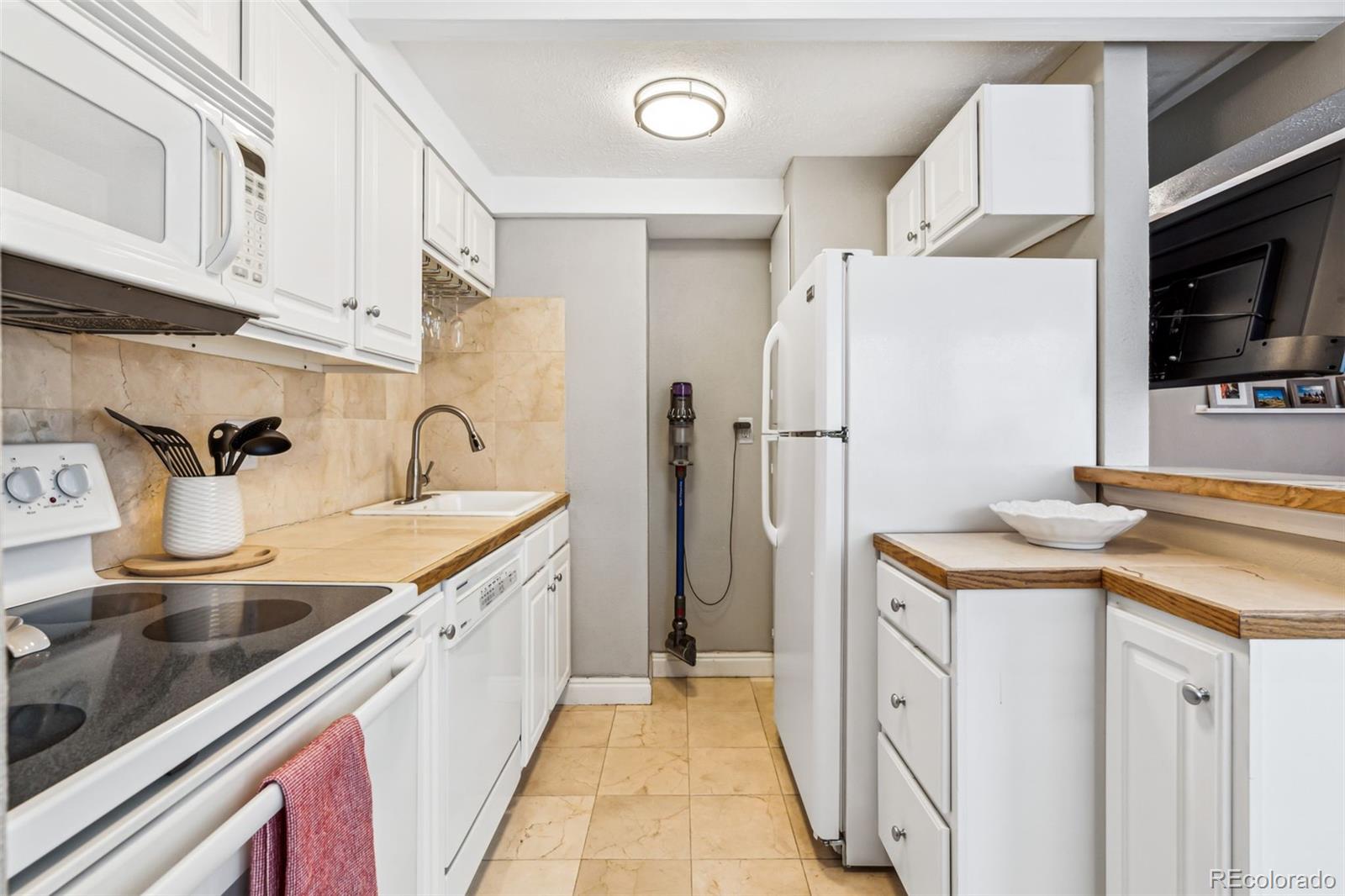 160 Jackson Street, Unit 5 Denver, CO 80206 - Photo 14 of 35 a kitchen with a sink a refrigerator and cabinets