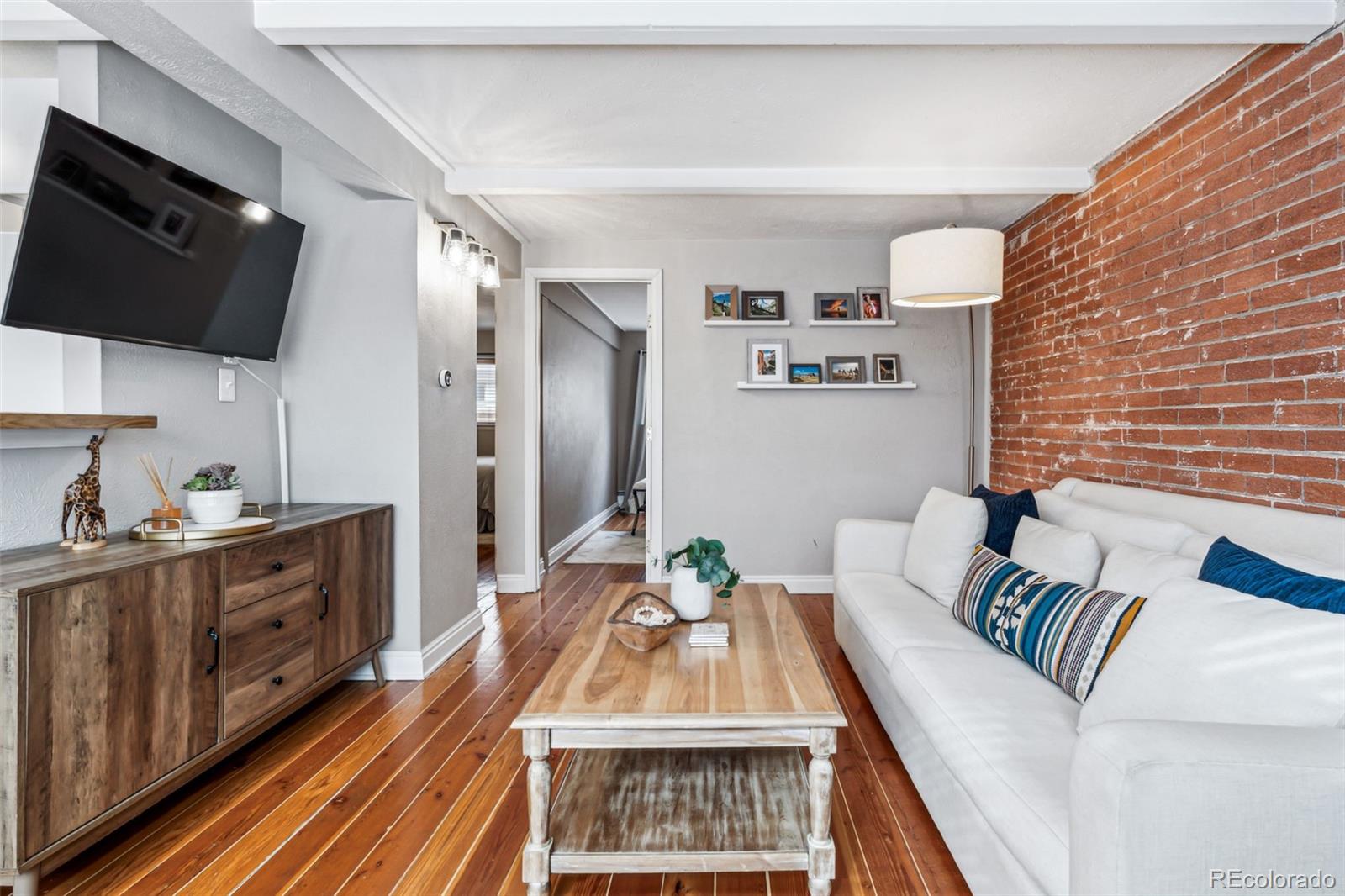 160 Jackson Street, Unit 5 Denver, CO 80206 - Photo 15 of 35 a living room with furniture a flat screen tv and a refrigerator