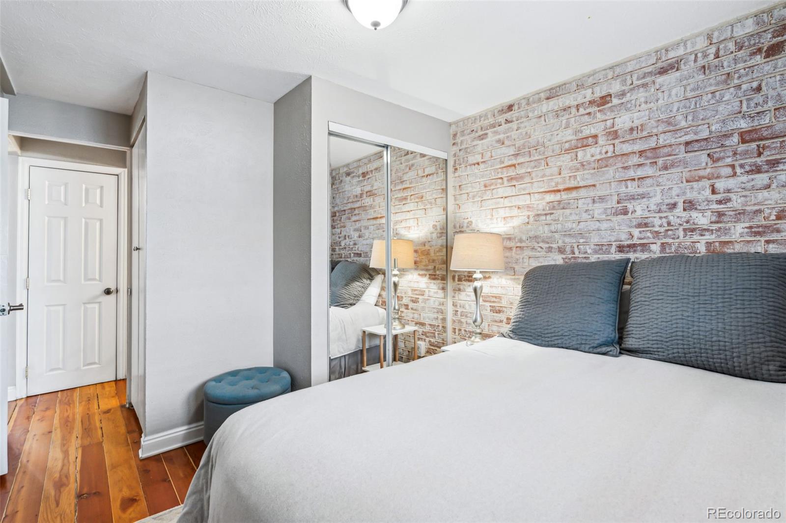 160 Jackson Street, Unit 5 Denver, CO 80206 - Photo 22 of 35 a bedroom with a bed and wooden floor