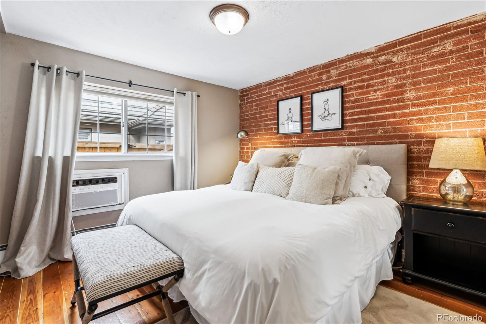 160 Jackson Street, Unit 5 Denver, CO 80206 - Photo 6 of 35 a bedroom with a bed and wooden floor