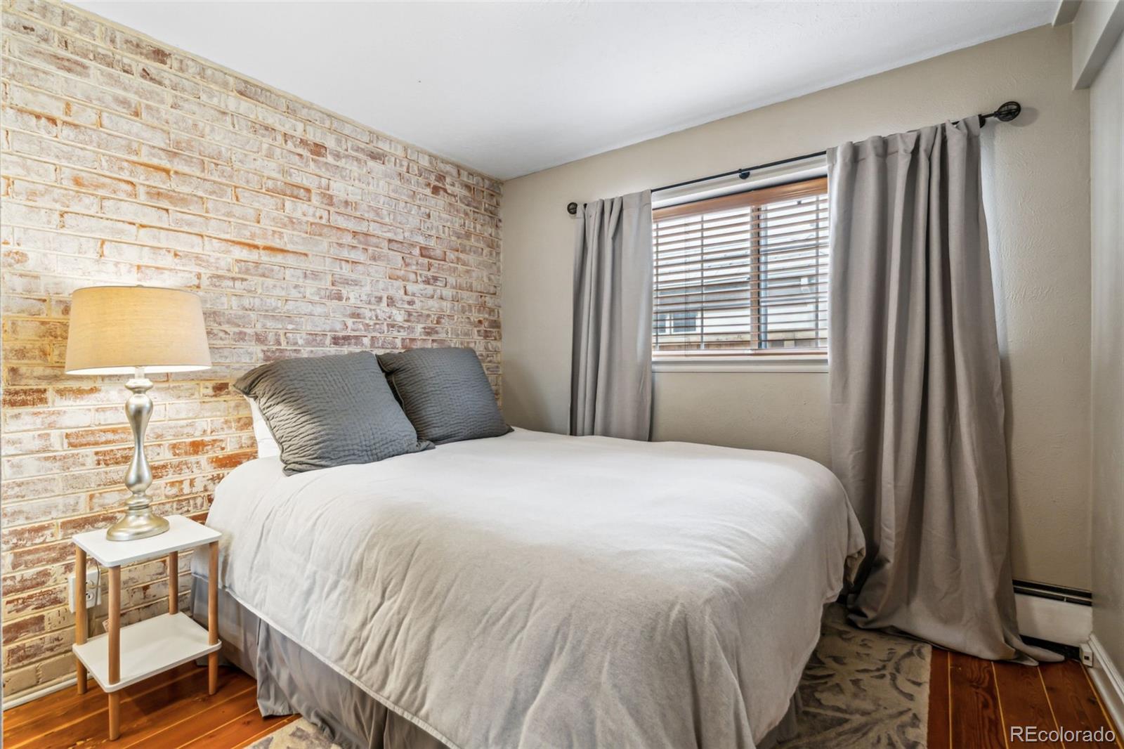 160 Jackson Street, Unit 5 Denver, CO 80206 - Photo 7 of 35 a bedroom with a bed and wooden floor