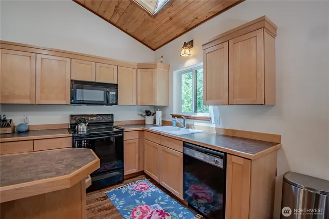 a kitchen with stainless steel appliances granite countertop a sink stove and microwave