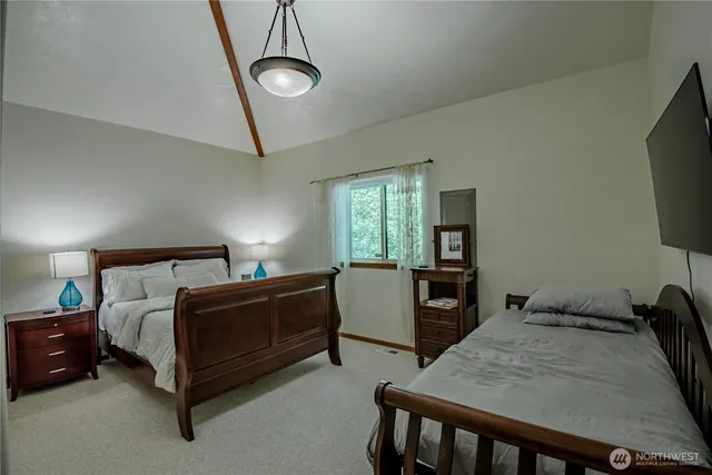 a bedroom with bed tv and window