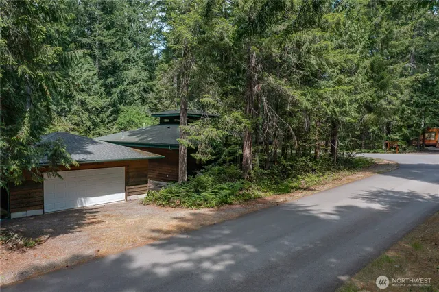 a view of a house with large tree and a yard
