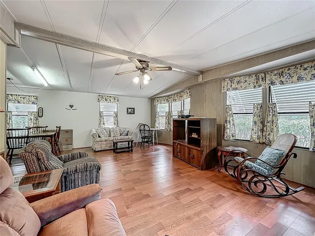 a living room with furniture flat screen tv and large window