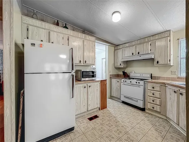 a kitchen with cabinets stainless steel appliances and a window