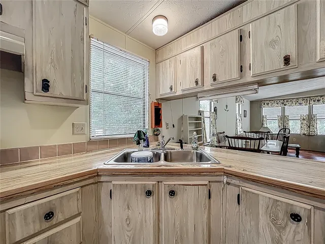 a kitchen with stainless steel appliances granite countertop a sink and white cabinets