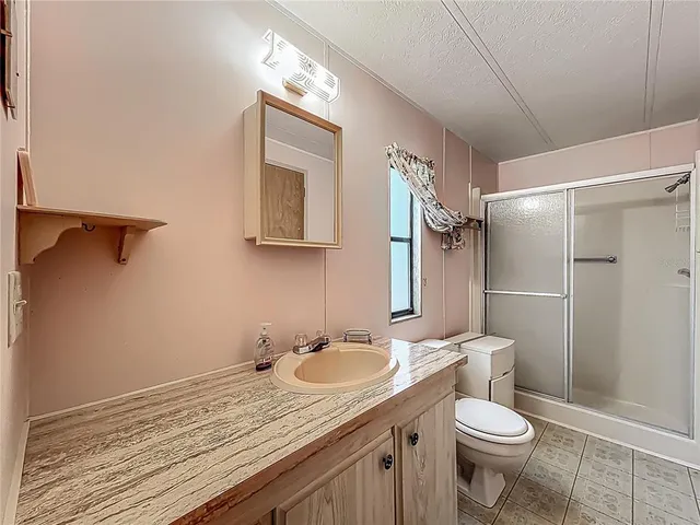 a bathroom with a granite countertop sink toilet and shower