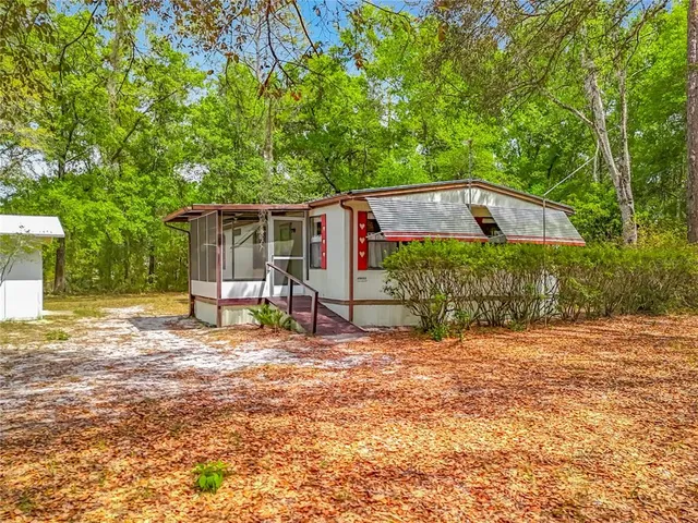 a backyard of a house with barbeque oven table and chairs