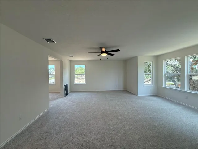 a view of a big room with windows and chandelier fan