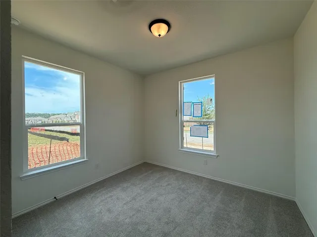 an empty room with windows and mirror