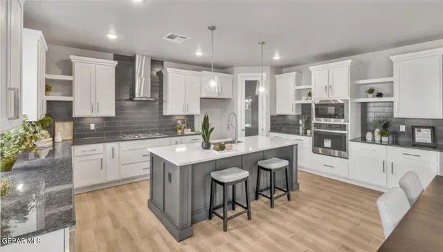 a kitchen with stainless steel appliances granite countertop a sink refrigerator and cabinets