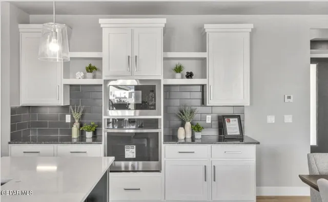 a kitchen with white cabinets and window
