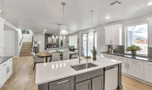 a kitchen with counter top space a sink cabinets and wooden floor