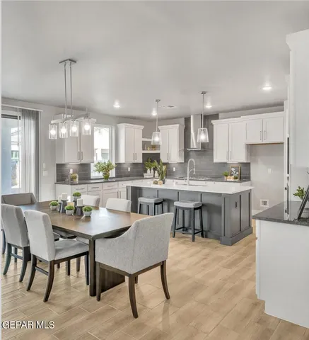 a kitchen with a dining table chairs wooden floor and kitchen view