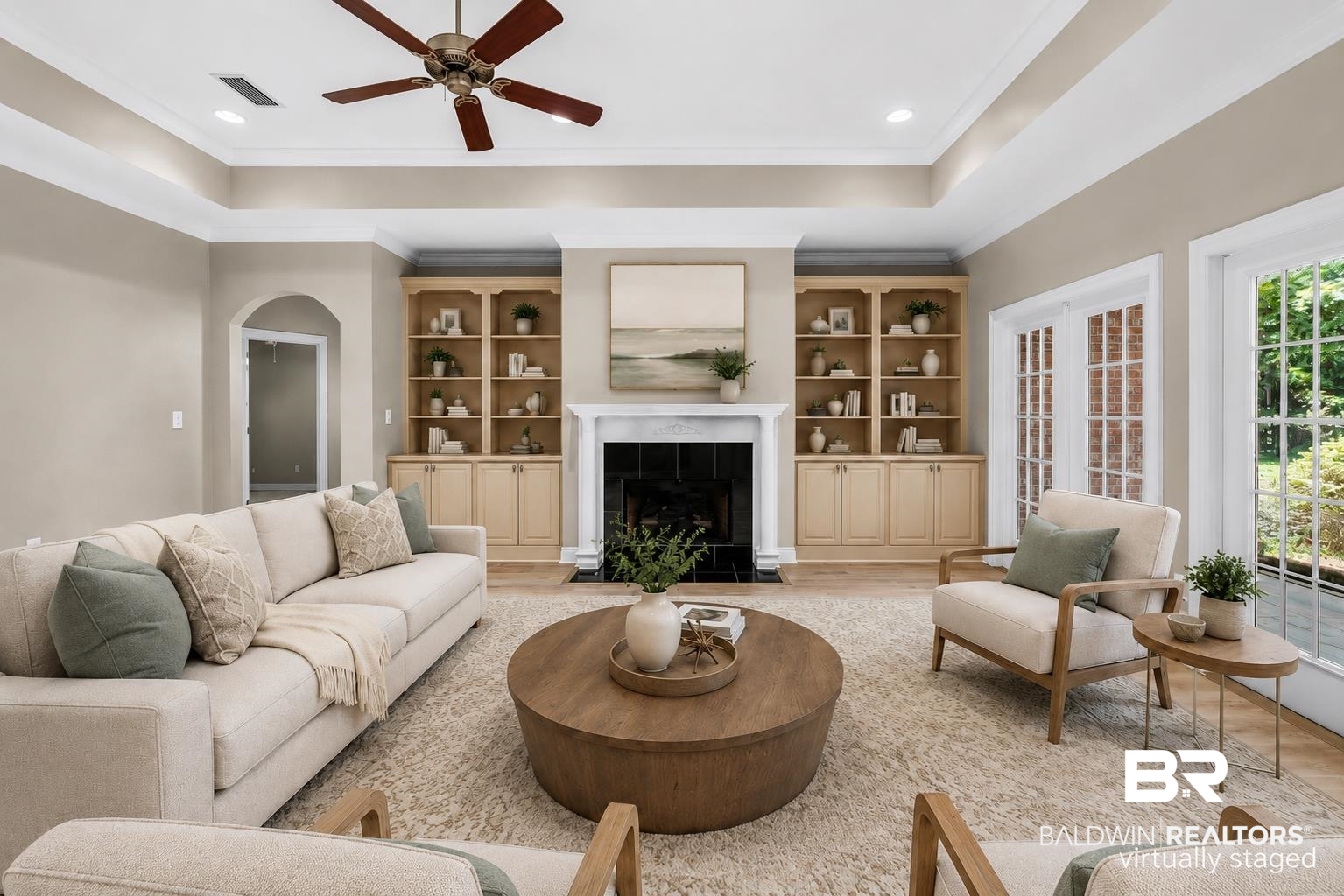 303 Savannah Circle Foley, AL 36535 - Photo 33 of 34 Spacious living area featuring a fireplace with a white mantel, built-in cabinetry, tray ceiling, and wood-finish flooring