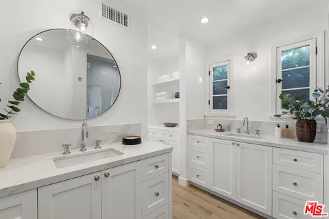 a bathroom with double vanity sinks and a mirror