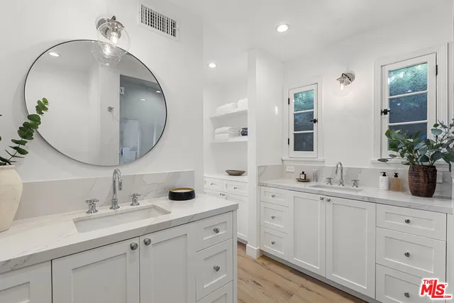 a bathroom with double vanity sinks and a mirror