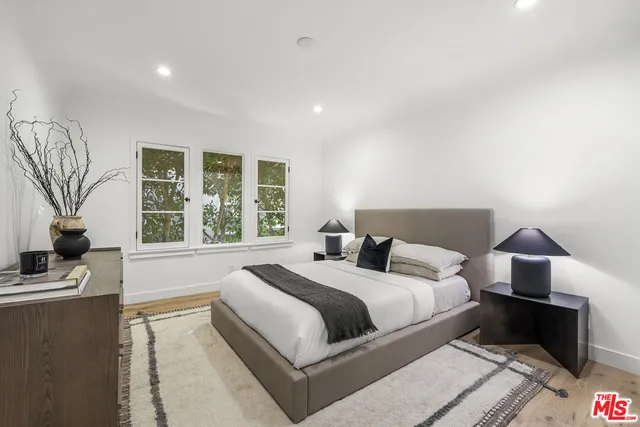 a bedroom with a bed and a large window