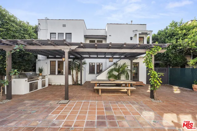 a view of a patio with a table and chairs under an umbrella