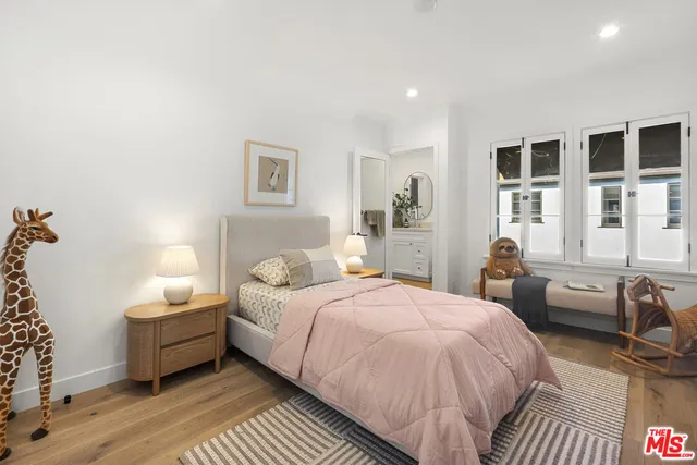 a bedroom with a bed and wooden floor