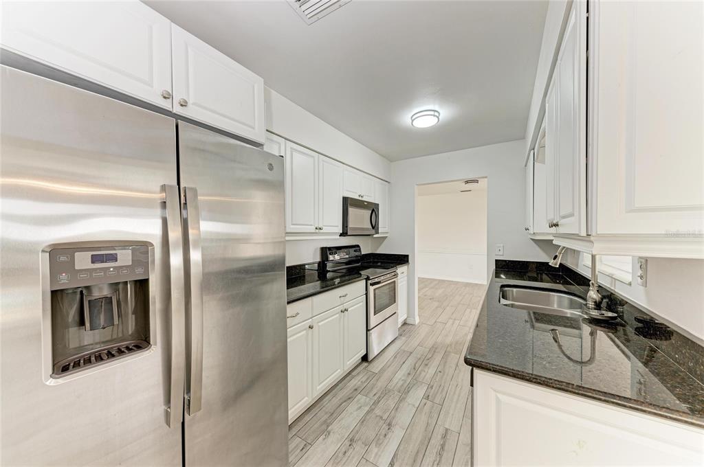 2544 Orsova Way Sarasota, FL 34231 - Photo 11 of 39 a kitchen with stainless steel appliances granite countertop a sink a stove and a refrigerator
