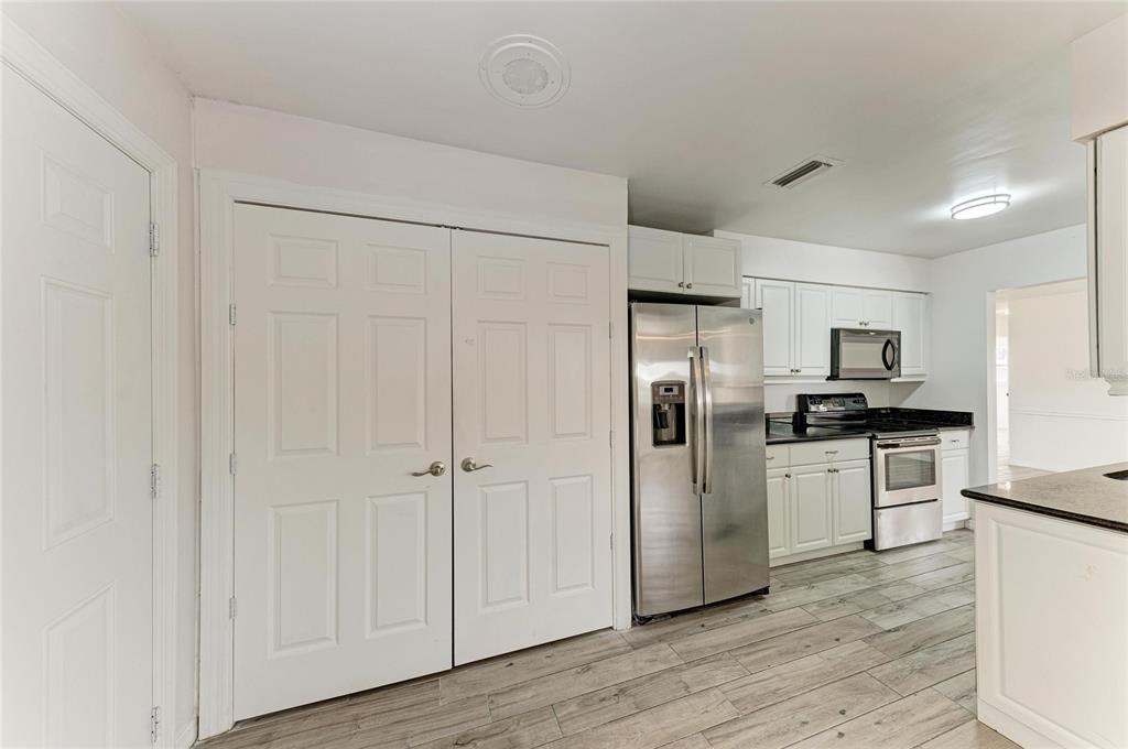 2544 Orsova Way Sarasota, FL 34231 - Photo 12 of 39 a kitchen with stainless steel appliances granite countertop a refrigerator microwave and white cabinets