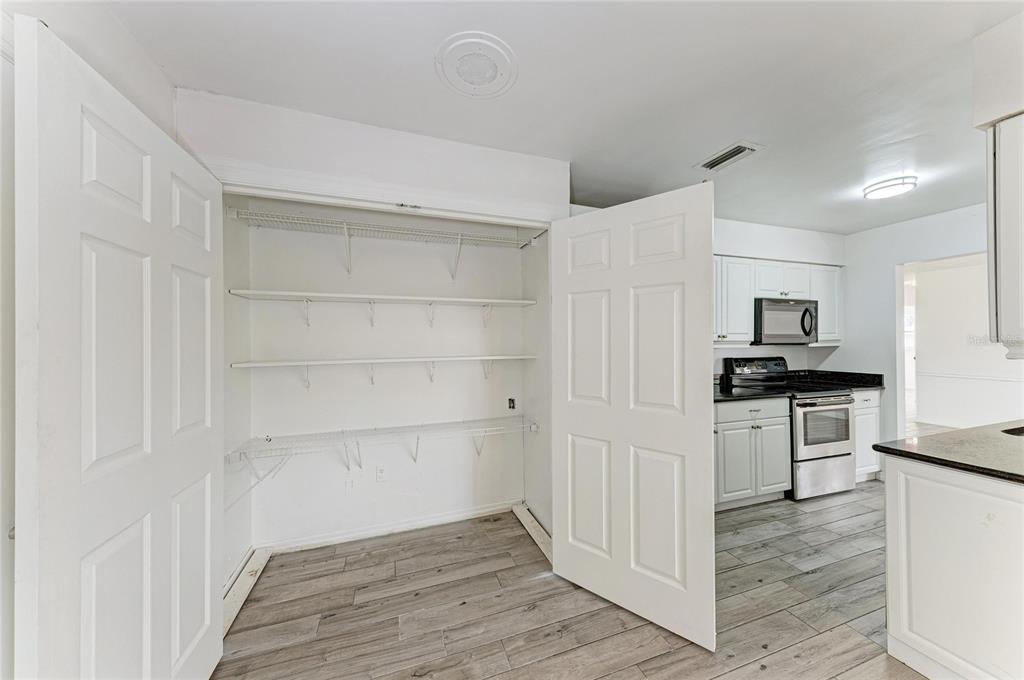 2544 Orsova Way Sarasota, FL 34231 - Photo 13 of 39 a kitchen with white cabinets and stainless steel appliances