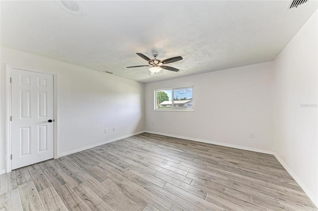 2544 Orsova Way Sarasota, FL 34231 - Photo 21 of 39 wooden floor in an empty room with a window