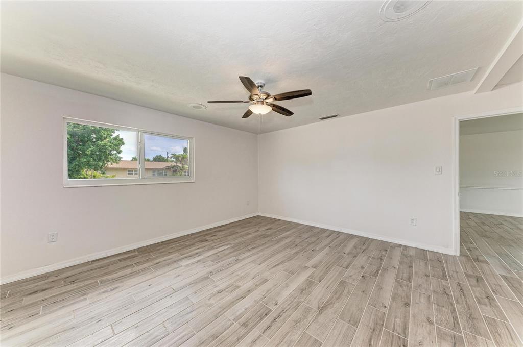 2544 Orsova Way Sarasota, FL 34231 - Photo 24 of 39 an empty room with wooden floor and ceiling fan