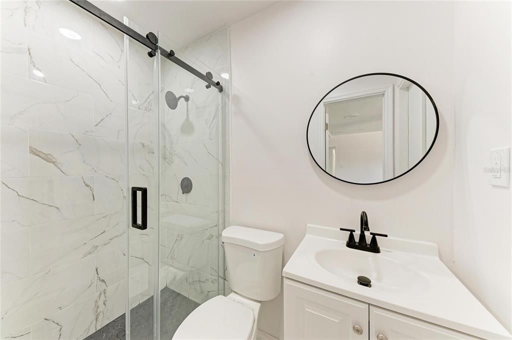 2544 Orsova Way Sarasota, FL 34231 - Photo 25 of 39 a bathroom with a sink a toilet and a mirror