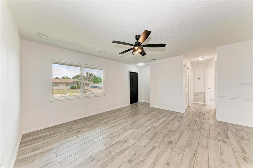 2544 Orsova Way Sarasota, FL 34231 - Photo 7 of 39 a view of an empty room with wooden floor and a window