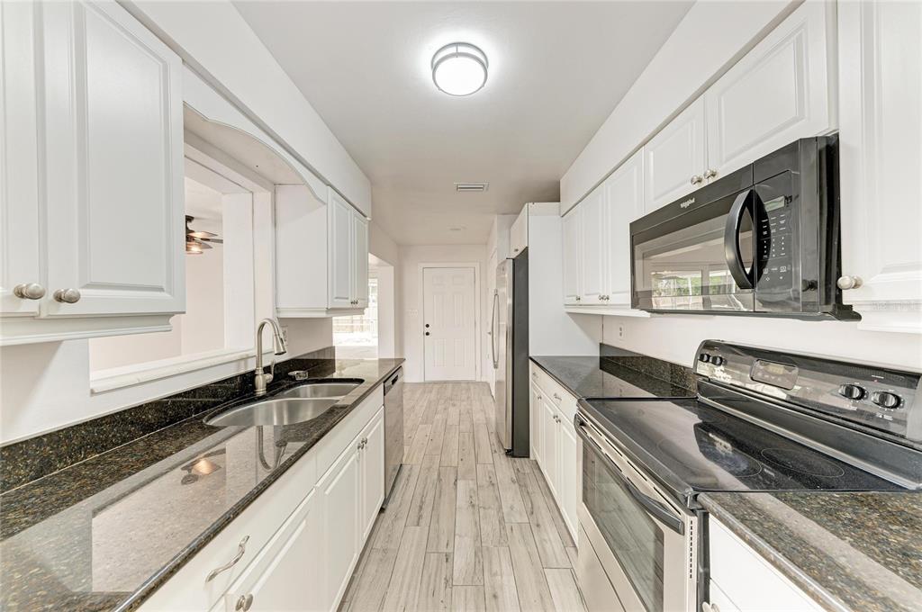 2544 Orsova Way Sarasota, FL 34231 - Photo 8 of 39 a kitchen with stainless steel appliances a stove sink and cabinets