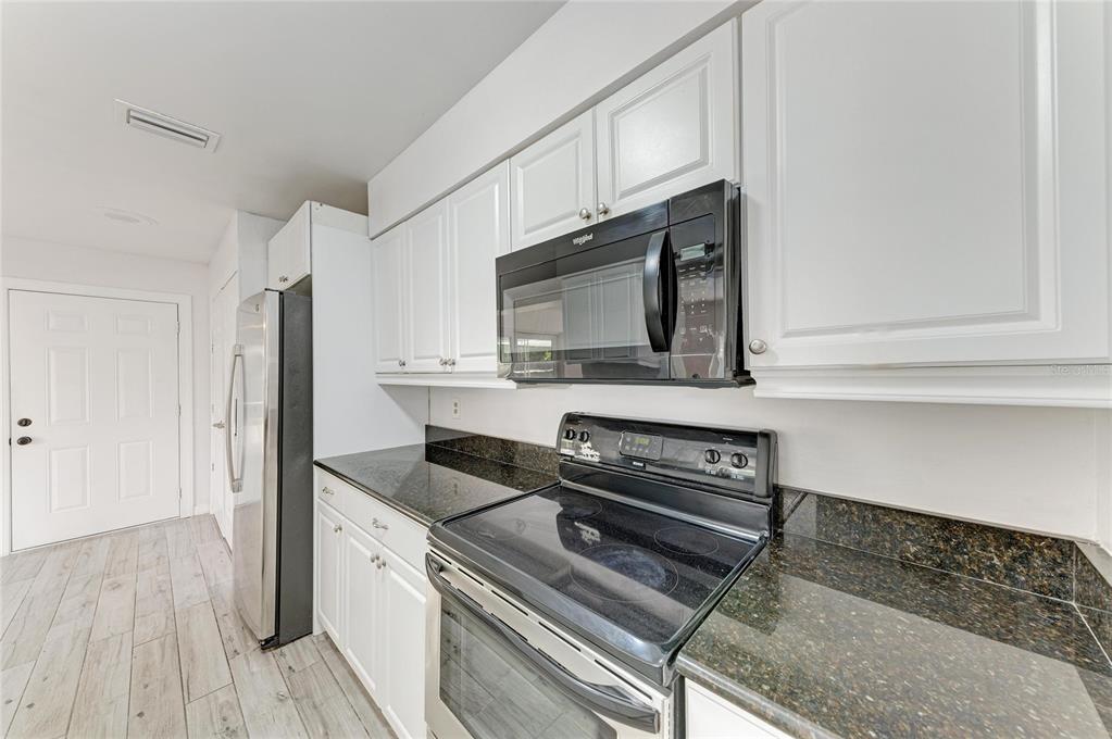 2544 Orsova Way Sarasota, FL 34231 - Photo 9 of 39 a kitchen with granite countertop a stove and a microwave