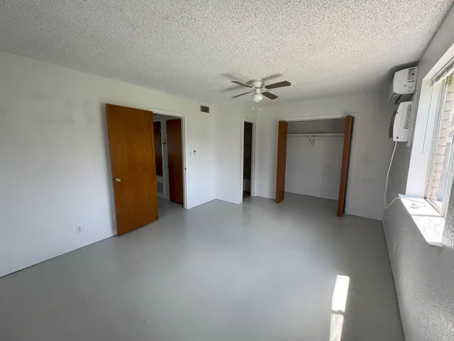 an empty room with windows and closet
