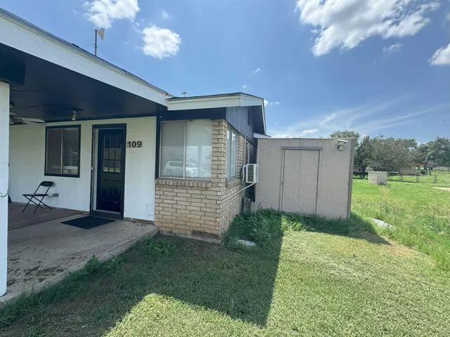 a view of a house with backyard and porch