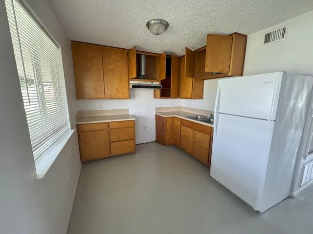 a kitchen with stainless steel appliances a refrigerator a sink a stove a microwave a counter top and cabinets