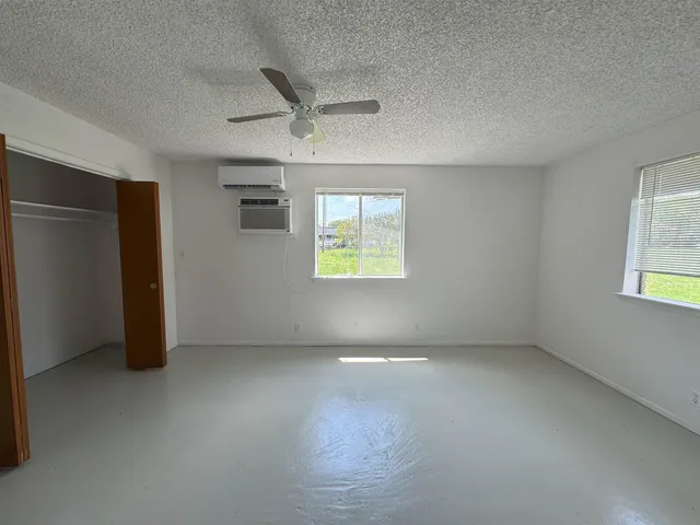 an empty room with windows and closet