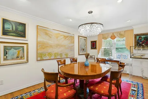 a dining room with furniture a large window and wooden floor