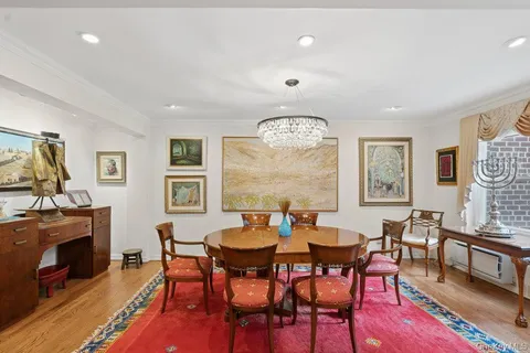 a view of a dining room with furniture a rug and wooden floor