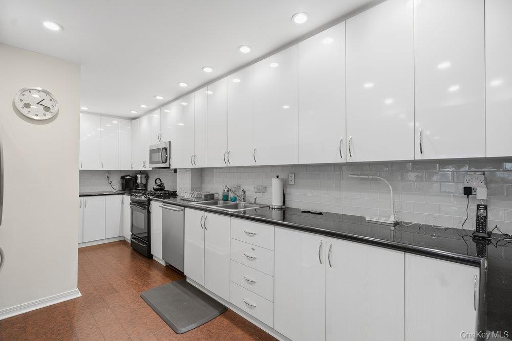 30 Stoner Avenue, Unit 1S Great Neck, NY 11021 - Photo 14 of 29 a kitchen with stainless steel appliances granite countertop a sink and cabinets